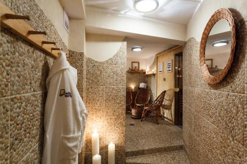 比亚韦斯托克薇拉帕斯特尔别墅酒店的浴室提供蜡烛、毛巾和镜子