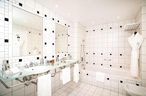 佩罗斯-吉雷克L'Agapa Hôtel - Spa Codage的白色瓷砖浴室设有2个盥洗盆和1个浴缸。