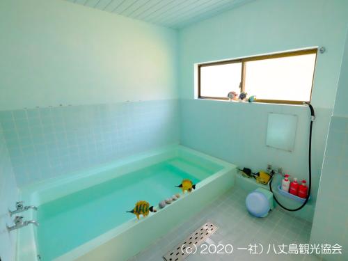KaminatoKokumin Shukusha Sun Marina的浴室设有蓝色瓷砖浴缸。