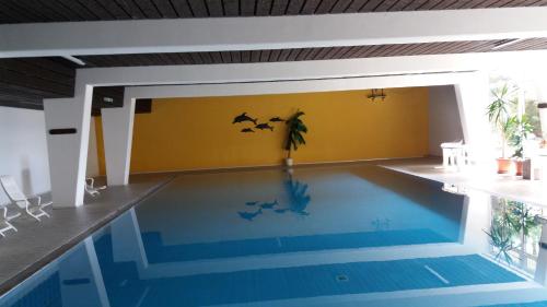 圣恩吉玛Ferienwohnung Reni的墙上有 ⁇ 蝠的房子里的一个游泳池