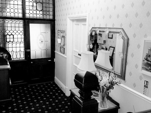 惠特比Crescent Lodge Guest House的一间设有镜子和一张带台灯的桌子的房间