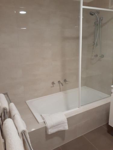 珀斯中央城市独家公寓 的带淋浴、浴缸和毛巾的浴室
