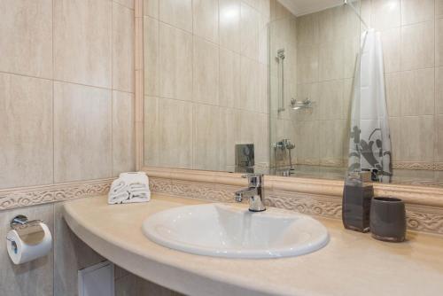 瓦尔纳Blue Lagoon Seafront Apartments的一间带水槽和镜子的浴室