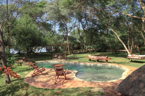 利文斯顿Mama Out of Africa的庭院内带野餐桌和椅子的游泳池