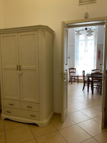 滨海波利尼亚诺Casa Sirena, Locazione Turistica的一间设有白色橱柜和用餐室的房间