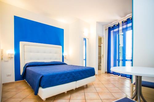 阿马尔菲拉皮亚泽塔旅馆的蓝色卧室,配有床和桌子