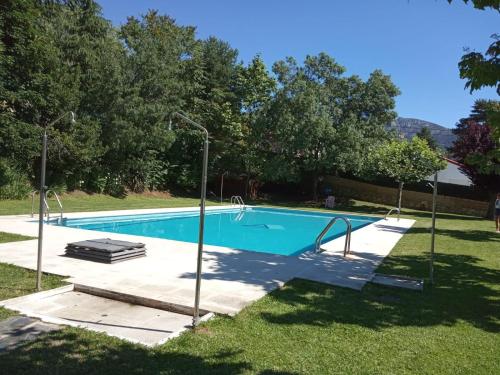 塞尔塞迪利亚La Casita de la Sierra Cercedilla的一个带两个灯的院子内的游泳池