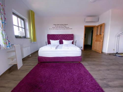 马格德堡apartHOTEL Magdeburg的一间卧室配有一张带紫色床头板和紫色地毯的床。