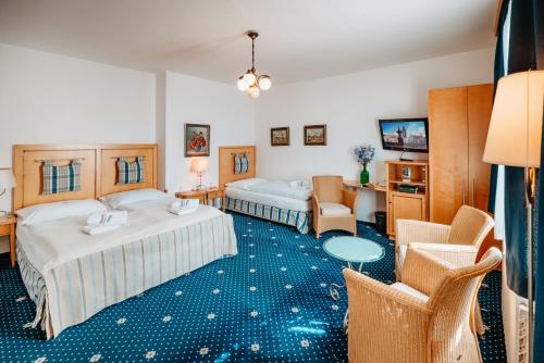 捷克布杰约维采克利卡酒店的酒店客房带两张床和一张桌子以及椅子。