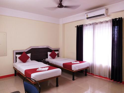 西里古里HOTEL NILADRII GALAXY的酒店客房设有两张床和窗户。