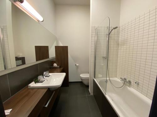 佩尔Hotel De Boskar Peer的一间带水槽、浴缸和卫生间的浴室