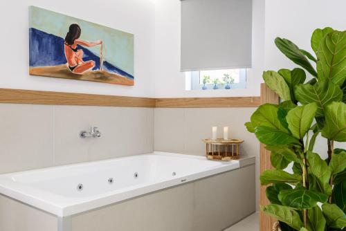 干尼亚Balance Hotel的带浴缸的浴室和一幅女子画
