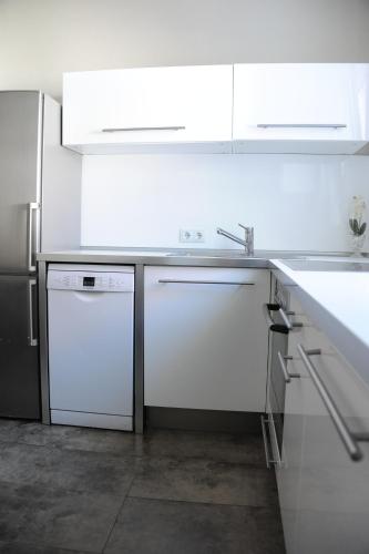 腓特烈港Ferienzimmer Ellisee, kontaktloser Check-in的白色的厨房配有水槽和洗碗机