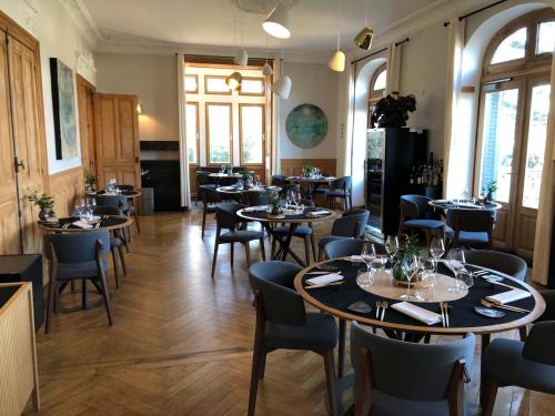Saint-Paul-en-JarezEclosion Château Hôtel & Restaurant的一间在房间内配有桌椅的餐厅