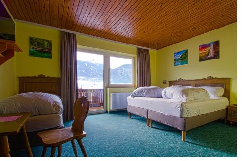 Jenig索勒特酒店的一间卧室设有两张床、一张桌子和一个窗口
