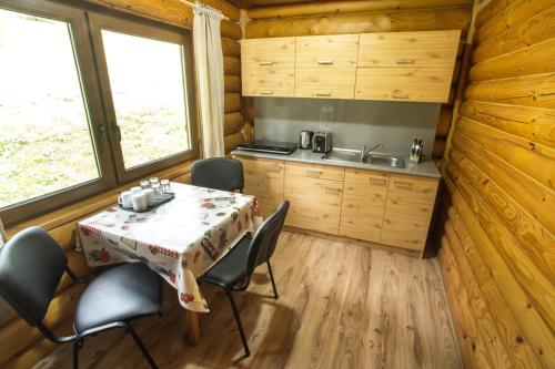 斯特拉特纳Ubytovanie Dobšinská Ľadová Jaskyňa的小木屋内的厨房和用餐室,配有桌椅