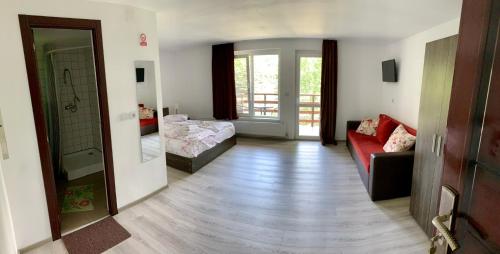 斯勒尼克Casa Flori de Sare的走廊上设有带红色沙发的客厅