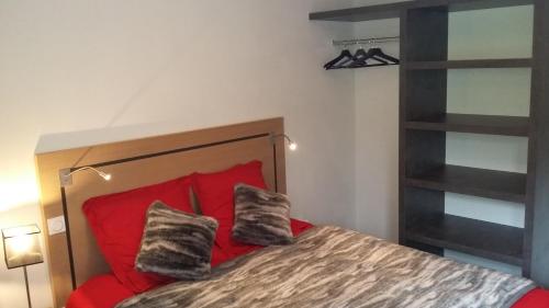 格尔姆T2 cabine vue montagne Valnéa Peyragudes的一间卧室配有红色的床和两个枕头
