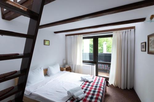 波亚纳布拉索夫Club Rossignol的一间卧室设有一张床和一个大窗户