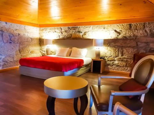 查韦斯卡萨斯诺瓦斯乡村Spa及活动酒店的一间卧室配有一张石墙床