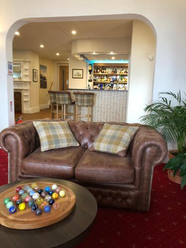 滨海韦斯顿昆士伍德酒店的客厅配有棕色的沙发和带球的桌子