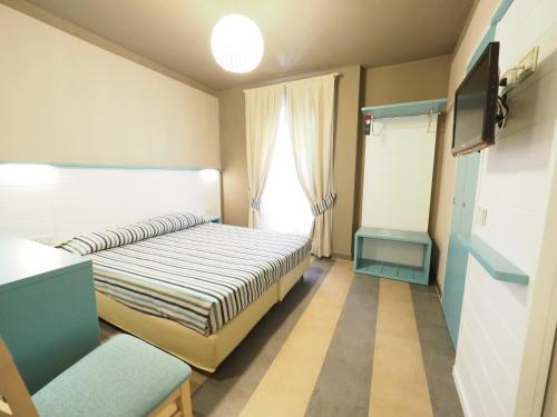 蒙特罗索阿尔马雷斯皮亚贾格酒店的小房间设有床铺和电视