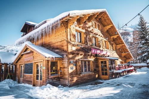 莱德萨阿尔卑斯Hotel Les Lutins的雪上雪下的木制建筑