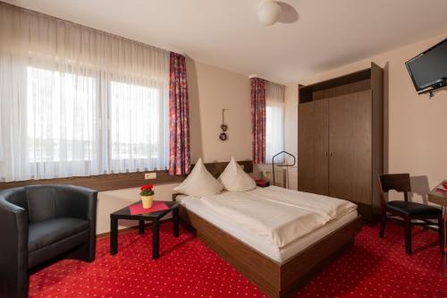 Überherrn哈斯菲尔德餐厅酒店的配有一张床和一把椅子的酒店客房
