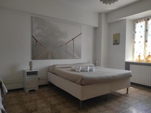 法尔科纳拉·玛里提马MONOLOCALI DA VINCI的卧室配有一张床铺,墙上挂有桥画