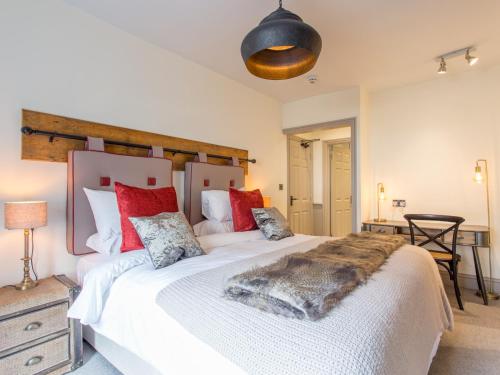 塔维斯托克The Cornish Arms的卧室配有带红色枕头的大型白色床