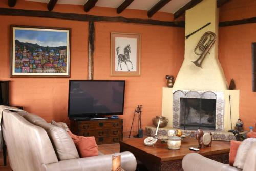 MachachiHacienda El Rejo的一间带电视和壁炉的客厅