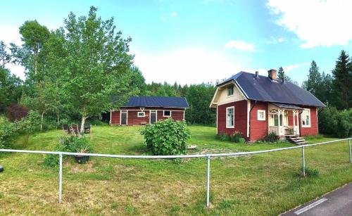 RansäterHolsby banvaktarstuga的两栋小房子,位于带围栏的院子内