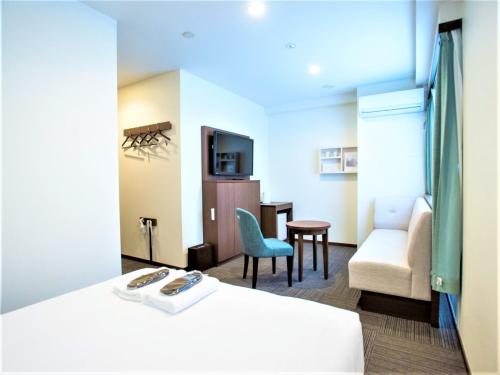 横滨SHIN YOKOHAMA SK HOTEL - Non Smoking - Vacation STAY 86111的酒店客房配有一张床、一把椅子和一张沙发