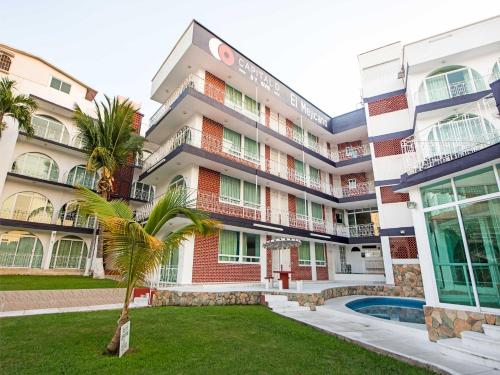 阿卡普尔科Capital O Hotel El Mejicano, Acapulco的前面有棕榈树的建筑