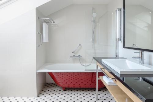 里加纳贝哥酒店的一间带红色浴缸和水槽的浴室
