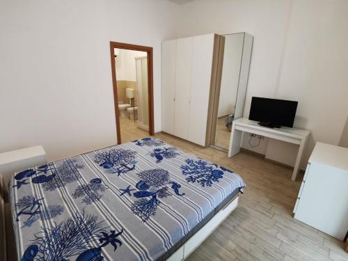 塔兰托All' Ombra del Faro - Mini Apartments的一间卧室配有一张床和一张书桌及电视