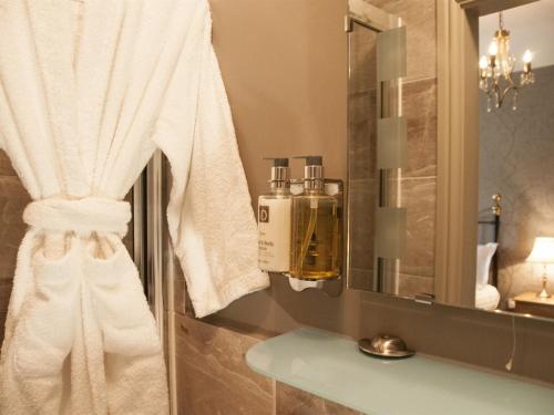 瑟斯克白杨树客房和小屋住宿加早餐旅馆的浴室提供白色毛巾和镜子