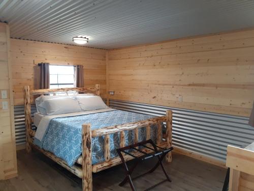 哥伦比亚瀑布Glacier Acres Guest Ranch的木制客房内的一间卧室,配有一张床