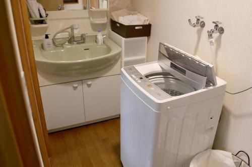 金泽Tsukuyomi Chuodori的一间带洗衣机和水槽的浴室