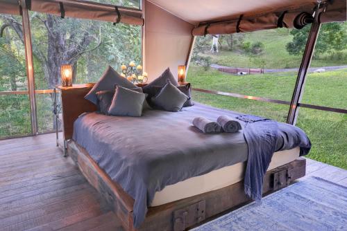 WoombyeStarry Nights Luxury Camping的一张位于带大窗户的房间内的床铺