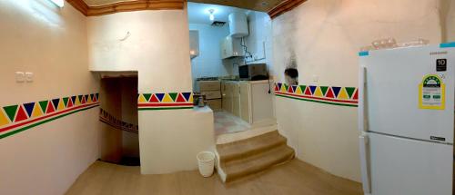 塔诺马بيت القرية التراثية的一间带冰箱的厨房和楼梯