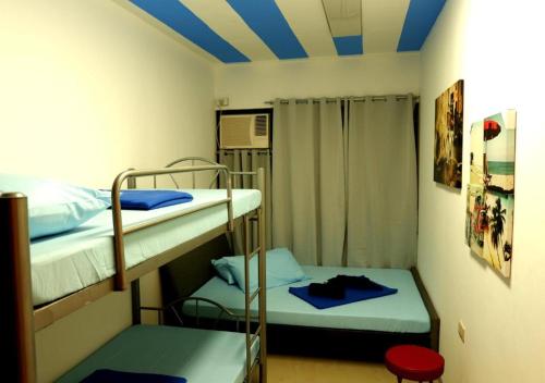 麦克坦宿雾拉普拉普 - 麦克坦区普吉特酒店的客房设有两张双层床和蓝色天花板。