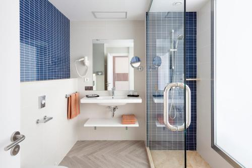 英格兰海滩Hotel Riu Papayas - All Inclusive的一间带玻璃淋浴和水槽的浴室