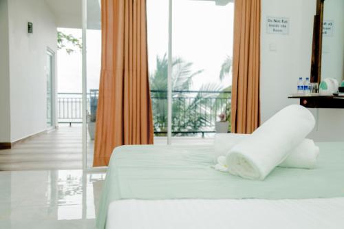 尼甘布Araliya Lagoon Park Resort的一间带白色床的卧室和一个阳台