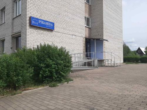 纳尔瓦Piramida Apartments的建筑的侧面有蓝色标志