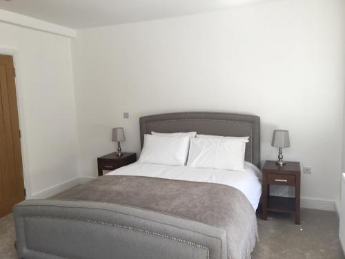 科巴姆Beautiful 1 BED Serviced APARTMENT COBHAM Town Centre的一间卧室配有一张带2个床头柜的大床