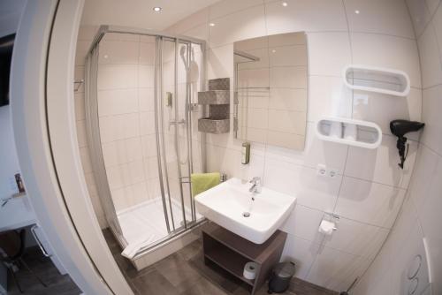 腓特烈港CityApartment K1 KLIMATISIERT的白色的浴室设有水槽和淋浴。