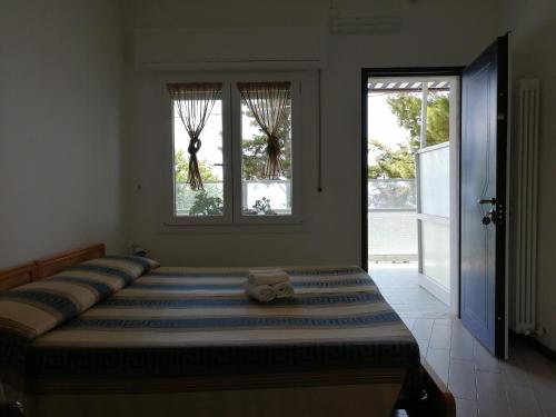 圣雷莫Villaggio Turistico LA VESCA的一间卧室设有一张大床和两个窗户
