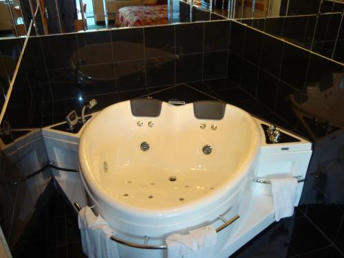 大急流城大急流城酒店的带浴缸的黑色瓷砖浴室