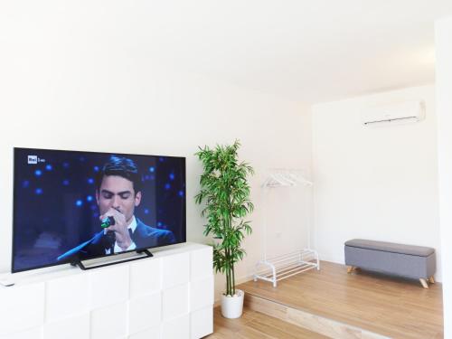 奥罗塞伊Guest House - La bella vita的客厅的白色墙壁上设有平面电视。